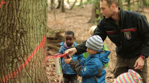 Förster mit Kindern beim Auszeichnen