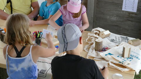 Kinder beim Stempeln von Stofftaschen