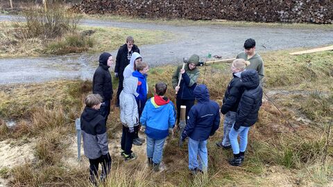 Einschlagen der Bodenhülsen für das Hinweisschild des Schulwaldes