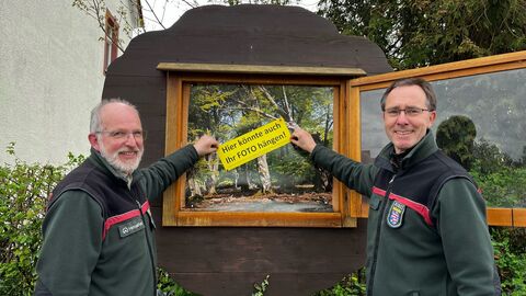 Ein auffälliger Schriftzug signalisiert die Fotomitmachaktion im Forstamtsschaukasten. Forstamtsleiter Holger Pflüger-Grone (re.) und Bereichsleiter Klemens Kahle beim Aufhängen des Schriftzuges.