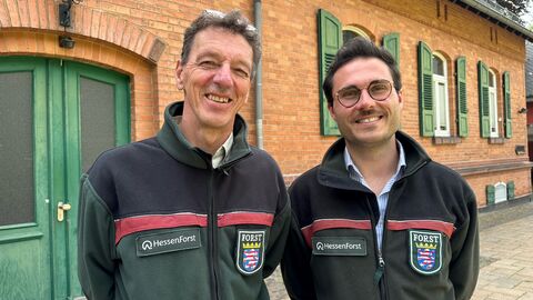 Links steht Ralf Bördner, rechts Jannik Altpeter. Beide vor dem Forstamt Wiesbaden-Chausseehaus