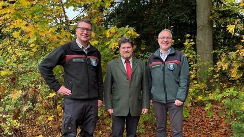 Drei Förster stehen vor einer herbslichten laubwaldkulisse. Der neue Forstamtsleiter Hendrick Hochhaus, Regionalleiter Harald Dersch und der kommissarische Forstamtsleiter David Nöllenheidt 