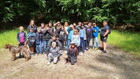 Schülerinnen und Schüler posieren mit Försterin Iris Beisheim im Seulingswald