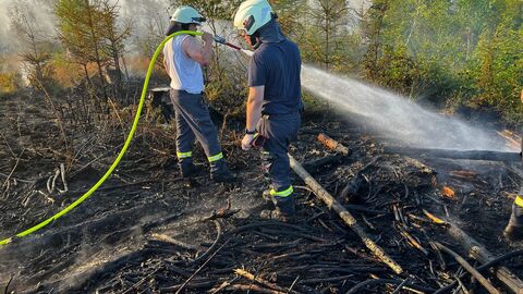 Zwei Feuerwehrmänner beim Ablöschen von Glutnestern. 