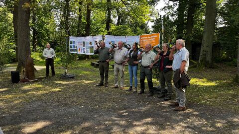 Jagdhornbläser vor Waldkulisse