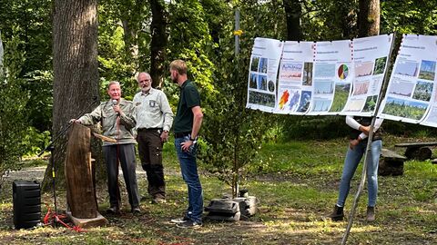 Menschen stehen vor Plakaten und referieren