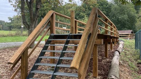 Man sieht eine Holzkonstruktion mit Treppe und Steg. 
