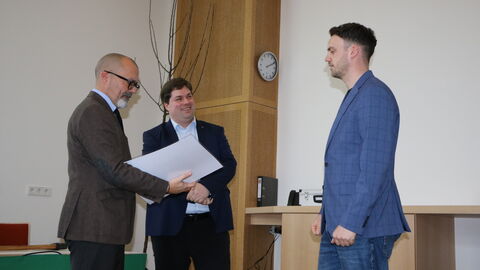 Staatsekretär Daniel Köfer (links) überreicht im Beisein des Leiters des FBZ, Dr. Hendrik Horn (Mitte) den Meisterbrief an Julius Eckhardt-Eiff (rechts).