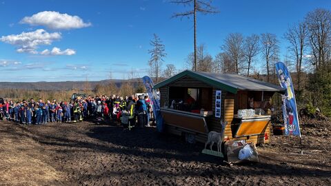 Ein Hüttenwagen Am Rande der Pflanzfläche. Viele Kinder und Jugendliche tummeln sich darum. 